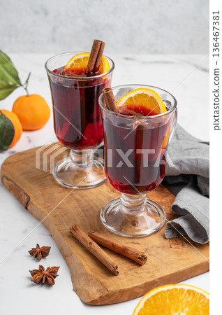 Two glasses of mulled wine, orange, cinnamon, and star anise on a wooden board Two glasses of mulled wine, orange, cinnamon, and star anise on a wooden board 136467381