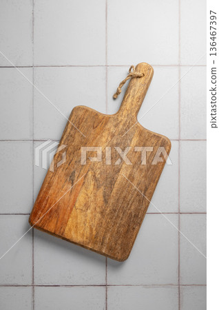 Wooden cutting board on a kitchen countertop blue tile background. Wooden cutting board on a kitchen countertop blue tile background. 136467397
