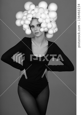 Woman posing with creative sphere headpiece in studio Woman posing with creative sphere headpiece in studio 136468154