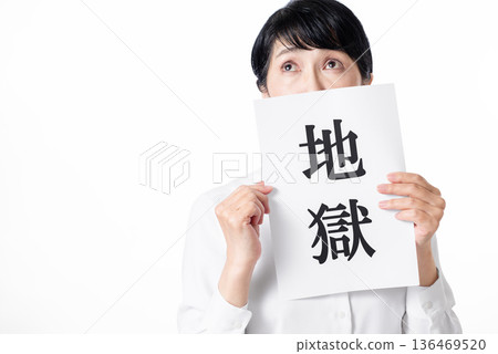一位焦慮的老婦人手裡拿著一張紙，上面寫著「地獄」這兩個字。 136469520
