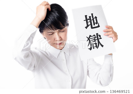 一位老婦人手裡拿著一張寫著「地獄」字樣的紙，雙手抱頭。 136469521