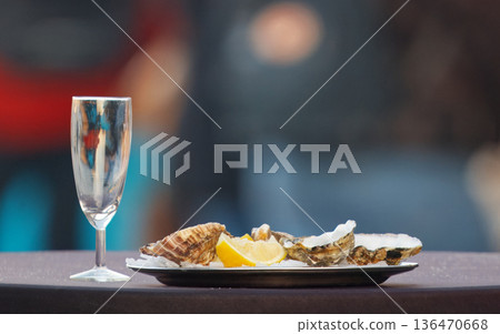 Elegant Oyster Plate With Lemon Slices And Champagne Glass For Fine Dining And Celebration Elegant Oyster Plate With Lemon Slices And Champagne Glass For Fine Dining And Celebration 136470668