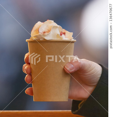 Hand Holding Paper Cup With Whipped Cream Topping, Cozy Coffee Moment in Winter Hand Holding Paper Cup With Whipped Cream Topping, Cozy Coffee Moment in Winter 136470677