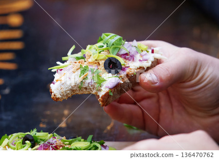 Eating Open-Face Sandwich with Colorful Toppings at Naplavka market 136470762