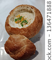 Creamy soup served in hollowed bread bowl with toppings. 136471888