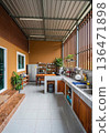 Spacious open-air kitchen with wooden elements and plants. 136471898