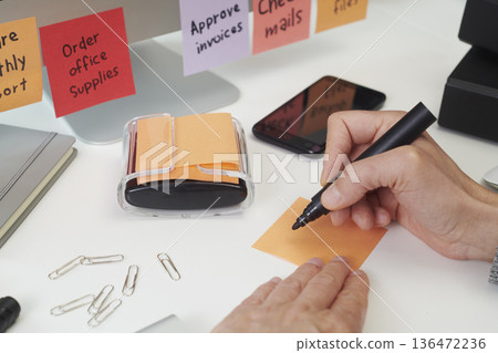 closeup of a man writing a note in an office desk closeup of a man writing a note in an office desk 136472236