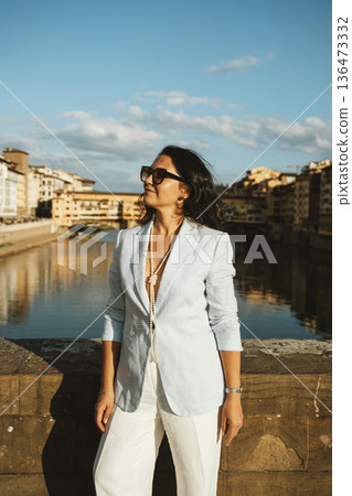 Woman Enjoying Riverside View in Stylish Outfit 136473332