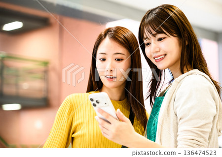 Two friends looking at a smartphone screen ■Photography cooperation: Kansai International Airport (KIX) Two friends looking at a smartphone screen ■Photography cooperation: Kansai International Airport (KIX) 136474523