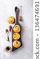 Freshly baked pastry rolls arranged on a wooden serving board with coffee and honey 136474691