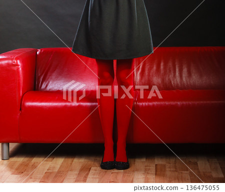 Fashion woman legs red pantyhose on couch 136475055