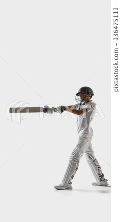 Young cricket batsman executing front foot shot in studio on white background. Banner Young cricket batsman executing front foot shot in studio on white background. Banner 136475111