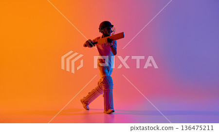 Teenage cricket player executing forward defensive shot in studio gradient light. Teenage cricket player executing forward defensive shot in studio gradient light. 136475211