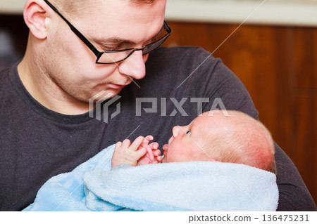 Father holding little newborn baby in blanket Father holding little newborn baby in blanket 136475231