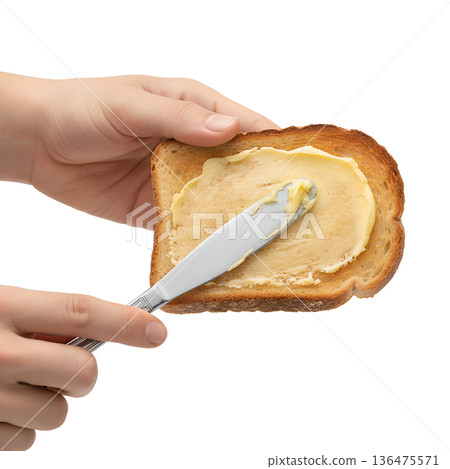 Hands spreading creamy butter over a warm, golden brown slice of toast, isolated. Perfect for breakfast concepts and comfort food Hands spreading creamy butter over a warm, golden brown slice of toast, isolated. Perfect for breakfast concepts and comfort food 136475571