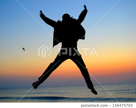 Boy silhouette jumping in the air, sunset sky 136475783
