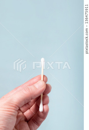 Hand holding cotton swab for personal hygiene 136475911