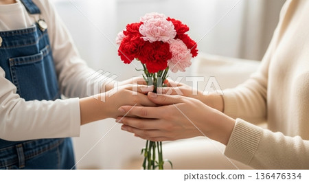 Mother's Day scene of parents and children giving carnations Mother's Day scene of parents and children giving carnations 136476334