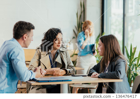 Diverse coworkers collaborating during office coffee break discussion 136476417