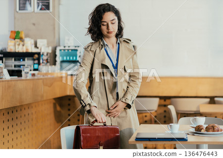 Businesswoman standing with briefcase at coffee break 136476443
