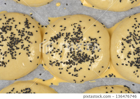 Close-up of raw burger buns with black sesame seeds Close-up of raw burger buns with black sesame seeds 136476746