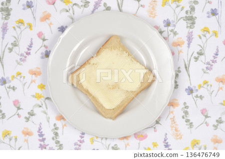 Butter toast on a white plate with floral background 136476749