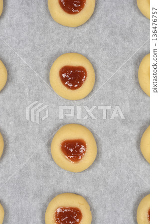 Vertical shot of unbaked thumbprint cookies with heart jam filling 136476757