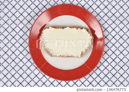 Slice of bread with cream cheese on red plate Slice of bread with cream cheese on red plate 136476773