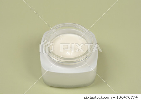 White face cream in a jar on a light green background White face cream in a jar on a light green background 136476774