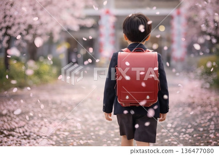一個男孩背著紅色書包，走在漫天飛舞的櫻花花瓣中。 136477080