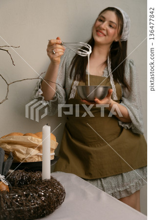 Cozy home Easter preparation woman lovingly whipping white glaze for festive traditional cake Cozy home Easter preparation woman lovingly whipping white glaze for festive traditional cake 136477842