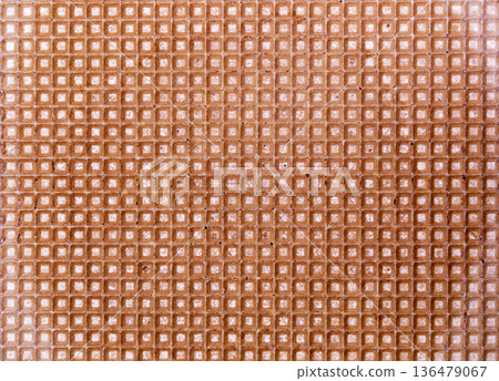 Background and texture of a surface of a confectionery waffle of brown color 136479067