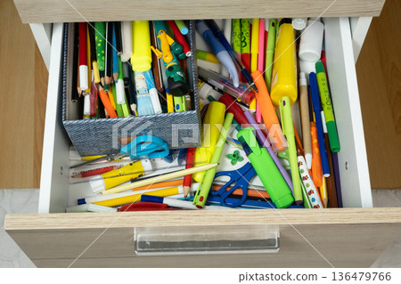 Messy Open Drawer Full of Colorful School Stationery and Pencils 136479766