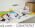 Crumpled Paper and Messy Stationery on White Desk Under Lamp 136479767