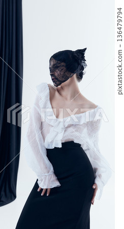 Woman in poetcore blouse with lace veil covering face in studio. Woman in poetcore blouse with lace veil covering face in studio. 136479794