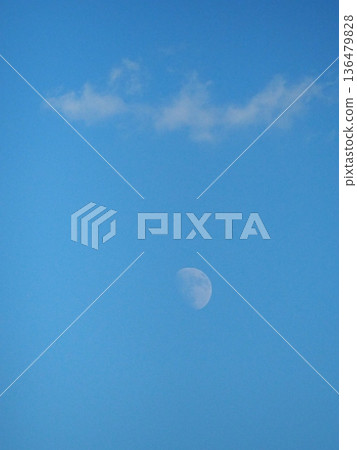 The moon behind the clouds in the blue sky Autumn sky The moon behind the clouds in the blue sky Autumn sky 136479828