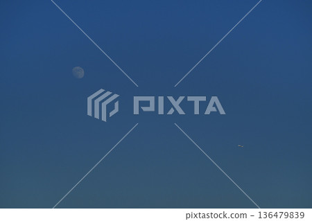 The moon behind the clouds in the blue sky Autumn sky The moon behind the clouds in the blue sky Autumn sky 136479839