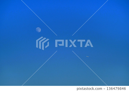 The moon behind the clouds in the blue sky Autumn sky 136479846