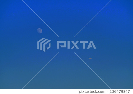 The moon behind the clouds in the blue sky Autumn sky 136479847