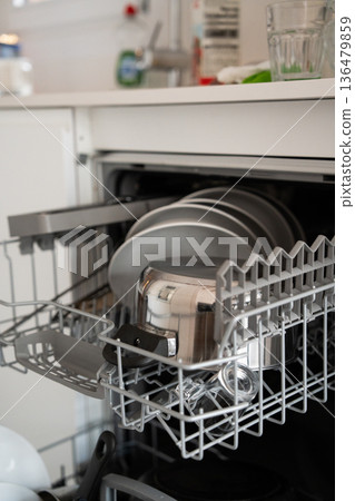 Dishwasher rack pulling out, full of kitchenware and clean dishes, illustrating modern home convenience, daily chores, and domestic efficiency Dishwasher rack pulling out, full of kitchenware and clean dishes, illustrating modern home convenience, daily chores, and domestic efficiency 136479859