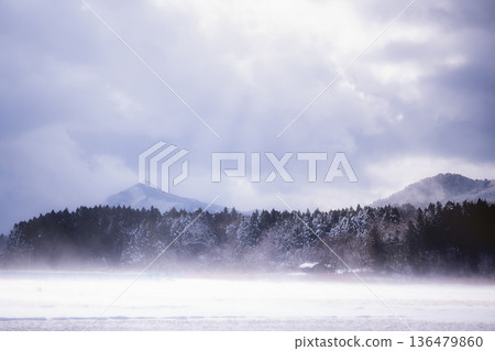 Mysterious snowscape and light: Divine sunlight illuminating the rising snow smoke 136479860