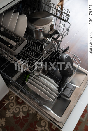 Open dishwasher with clean dishes, pots, pans, and cutlery inside, showing a modern kitchen appliance simplifying household chores and daily routine Open dishwasher with clean dishes, pots, pans, and cutlery inside, showing a modern kitchen appliance simplifying household chores and daily routine 136479861