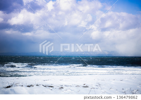 The winter sea on a clear day: A spectacular view of the white waves of the Sea of Japan and Sado Island 136479862
