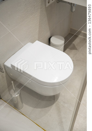 Modern wall-hung toilet in a clean contemporary bathroom, emphasizing hygiene and minimalist design for interior decor, sanitation, and home renovation concepts Modern wall-hung toilet in a clean contemporary bathroom, emphasizing hygiene and minimalist design for interior decor, sanitation, and home renovation concepts 136479893