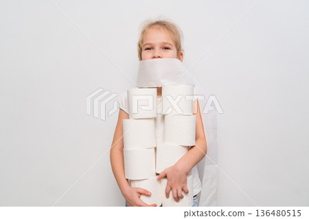 Child holds toilet paper rolls in playful setup at home Child holds toilet paper rolls in playful setup at home 136480515