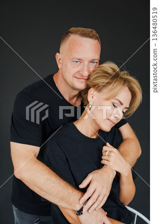 Couple embracing in studio setting during casual photo session 136480519
