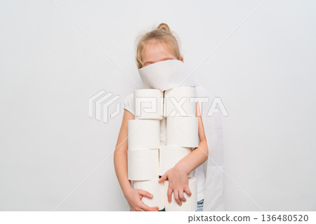Child plays with toilet paper rolls in a clean indoor space 136480520