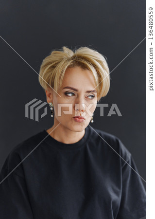 Woman makes a thoughtful expression in a studio Woman makes a thoughtful expression in a studio 136480559