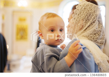 Child being held during a religious ceremony in a church Child being held during a religious ceremony in a church 136480603