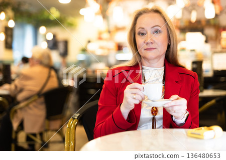 Portrait of stylishly dressed woman with cup of coffee in restaurant 136480653